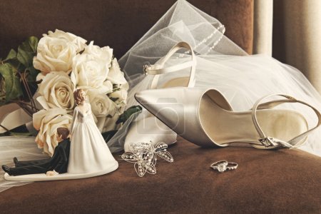 Bouquet of white roses and wedding shoes on chair