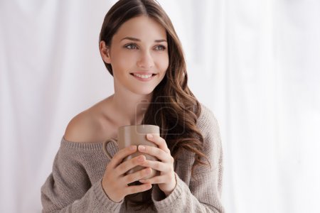 beautiful woman drinking coffee, sitting by window