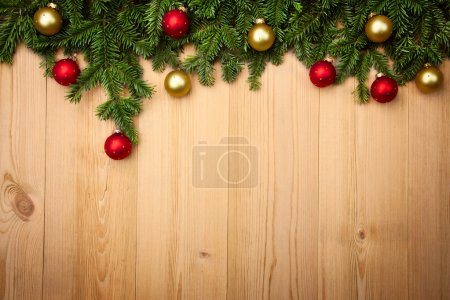 Christmas background with firtree and baubles on wood