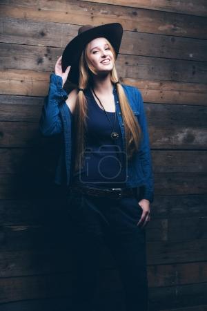 Cowgirl jeans fashion woman with long blonde hair. Standing agai