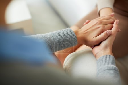 Psychiatrist hands holding palm of patient