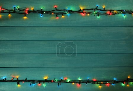 Colorful Christmas lights on wooden planks background