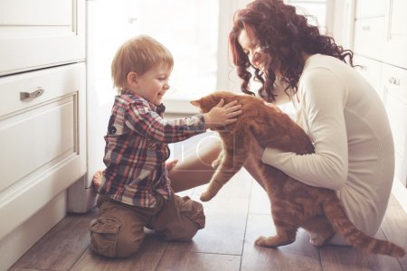 Mother and child playing with cat
