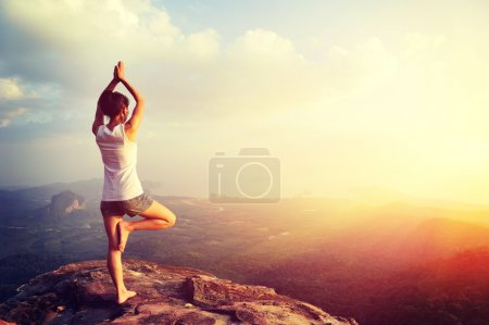 Woman meditating on mountain
