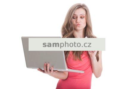 Undecided woman holding credit card and a laptop