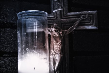 Crucifix  near lighting candle