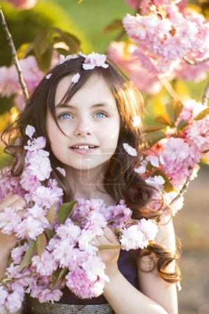 Little girl amid cherry blooming