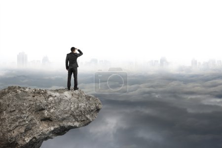 man looking on cliff with gray cloudy sky cityscape  background