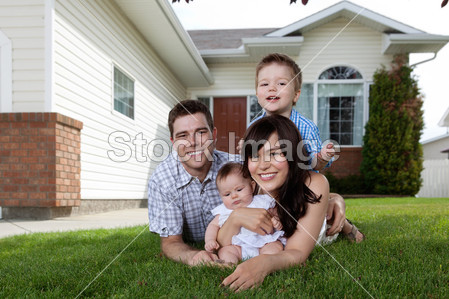 Happy Family of Four Lying Down on Grass
