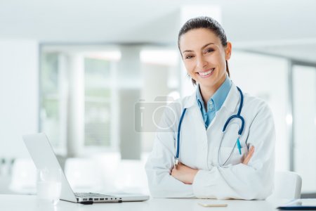 Confident female doctor at office desk