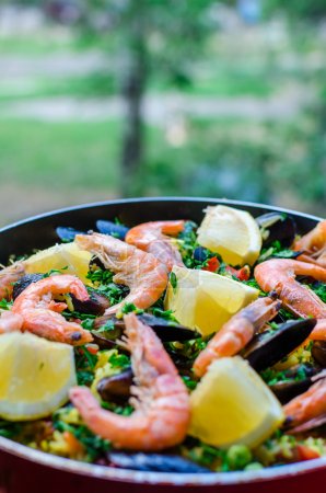 Close up classic seafood paella with mussels, shrimps and vegetables