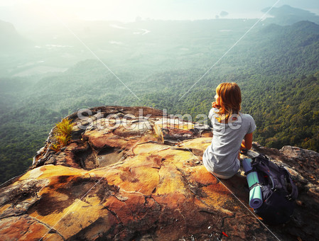 Young woman sitting on a rock