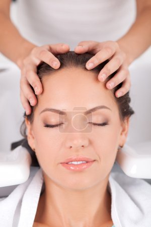 Attractive young woman has her hair washed in salon