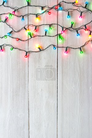 christmas lights over white painted planks for background