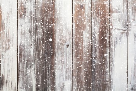 Christmas background with falling snow over wooden background