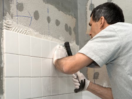 Man Tiling A Wall