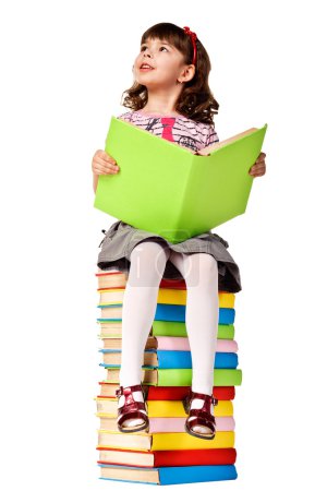 Little girl sitting on stack of books.